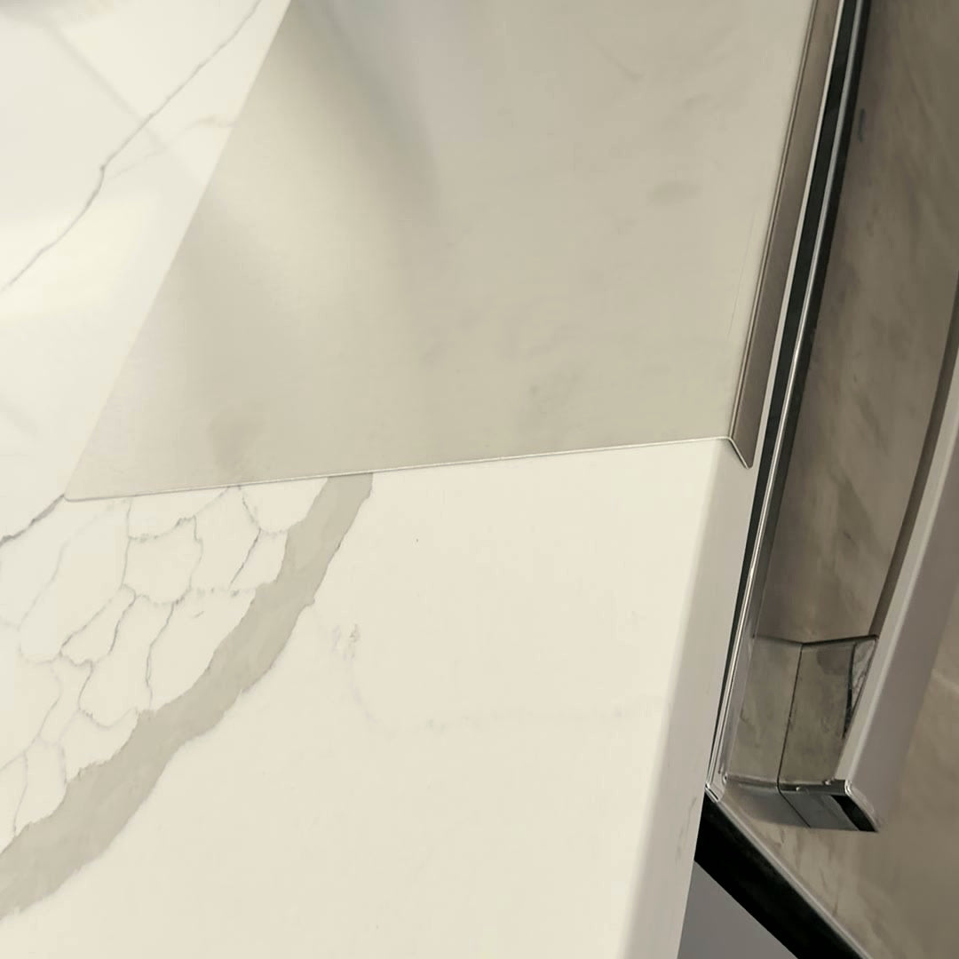 The L-shaped lip hooked over a quartz counter edge