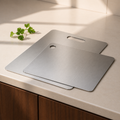 Two flat stainless steel cutting boards in complementary sizes